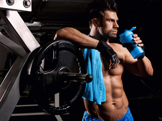 Wall Mural - man at the gym drinking from the mixer