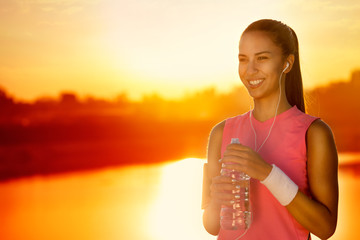 Smiling sporty woman with bottle of water