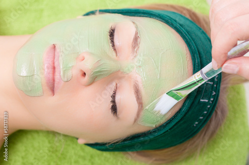 Fotografie, Obraz Beauty salon. Cosmetician applying facial mask at woman face.