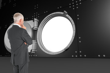 Poster - Composite image of thoughtful businessman standing back to camer