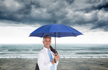 Poster - Composite image of businessman holding umbrella smiling at camer