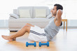 © lightwavemedia - Young man doing abdominal crunches in the living room