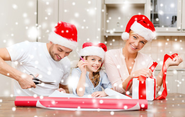 Canvas Print - smiling family in santa helper hats with gift box