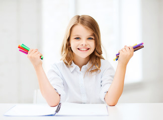 Wall Mural - smiling girl showing colorful felt-tip pens