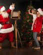 © Milles Studio - Santa Claus taking picture of cheerful woman with little girl by