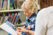 © Tyler Olson - Boy With Teacher Looking At Book In Library