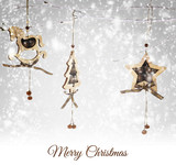 Fototapeta  - Christmas wooden ornaments hanging on snowy branch