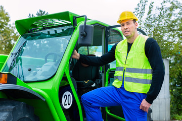 builder on site in front of construction machinery