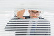 Close-up of a businessman peeking through blinds in office
