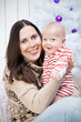 © golovianko - Mother and child under the decorated Christmas tree