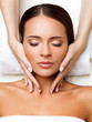 © puhhha - Face Massage. Close-up of a Young Woman Getting Spa Treatment.