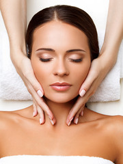 Wall Mural - Face Massage. Close-up of a Young Woman Getting Spa Treatment.