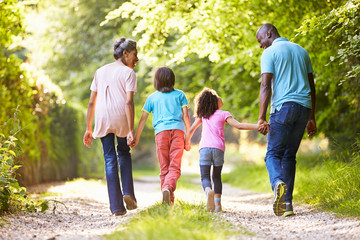 Grandparents With Grandchildren Walking Through Countryside