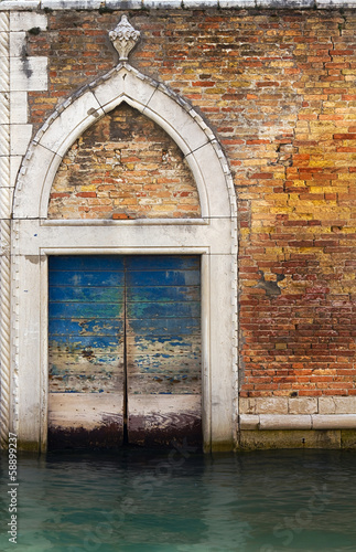 Wooden front door in Venice canal.