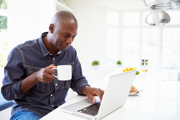 African American Man Using Laptop At Home