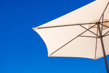 Part Of White Umbrella On Background Blue Sky At The Beach