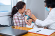 © Mediteraneo - Baby boy held by his mother examined by pediatrician