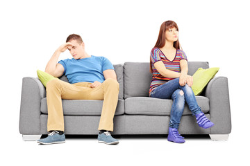 Poster - Sad heterosexual couple sitting on a sofa after an argument