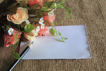 Wall Mural - flower laying on brown canvas with blank paper