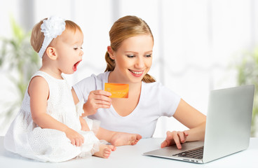 Fototapete - mother and baby  with a laptop and credit card