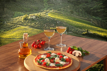 Italian pizza and glasses of white wine in Chianti, Italy