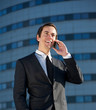 © mimagephotos - Portrait of a young business man talking on cellphone outdoors