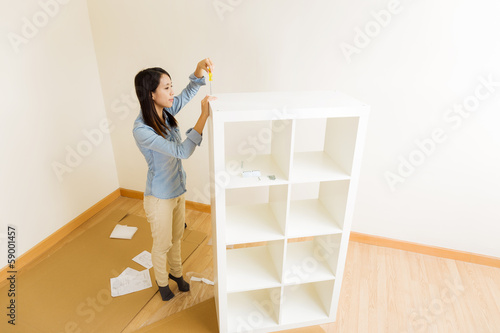 Fotografie, Tablou Asian woman assemble a white bookshelf