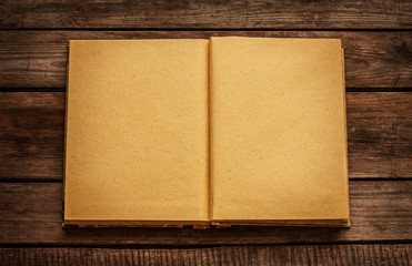 Old blank open book on vintage planked wood table