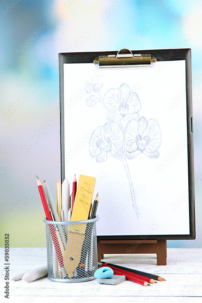 Sketch with professional art materials, on wooden table