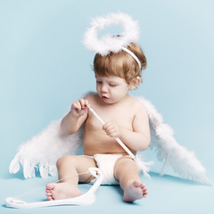 Wall Mural - Beautiful little angel on blue background