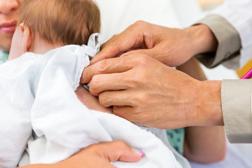 Fototapete - Doctor's Hands Examining Newborn Babygirl With Stethoscope