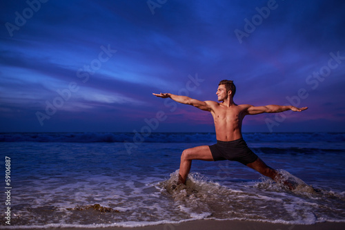 Fotografie, Obraz Man in yoga warrior pose standing in ocean water