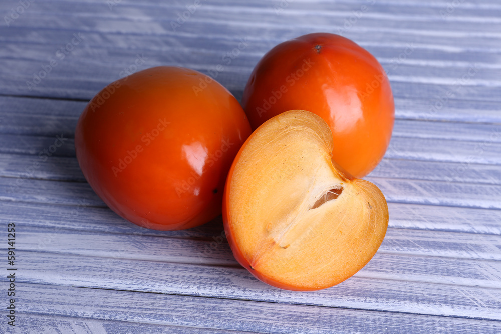 Ripe persimmons on wooden background