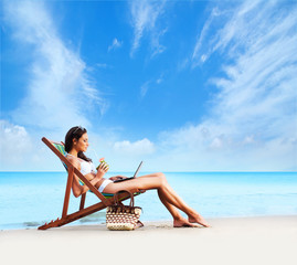 Wall Mural - A young woman relaxing with a cocktail on a beautiful beach