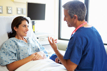 Wall Mural - Male Nurse Talking With Female Patient In Hospital Room