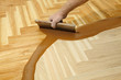 © sima - Home renovation varnishing oak parquet floor worker hand, brush