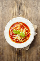 Canvas Print - Top view of tomato and pepper soup on wooden table