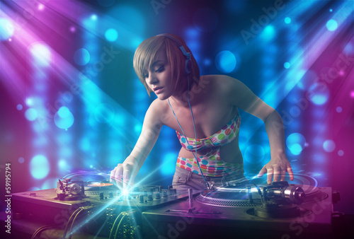 Board z aluminiowym obramowaniem DJ dziewczyna miksująca muzykę w klubie z niebieskimi i fioletowymi światłami
