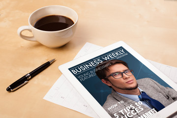 Wall Mural - tablet pc showing magazine on screen with a cup of coffee on a d