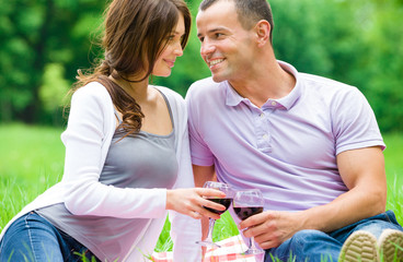 Fototapete - Beautiful couple drinks wine in park