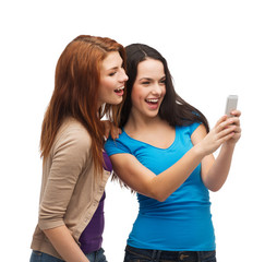 Wall Mural - two smiling teenagers with smartphone