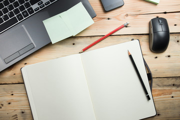 Workplace, laptop and notepad on wooden table