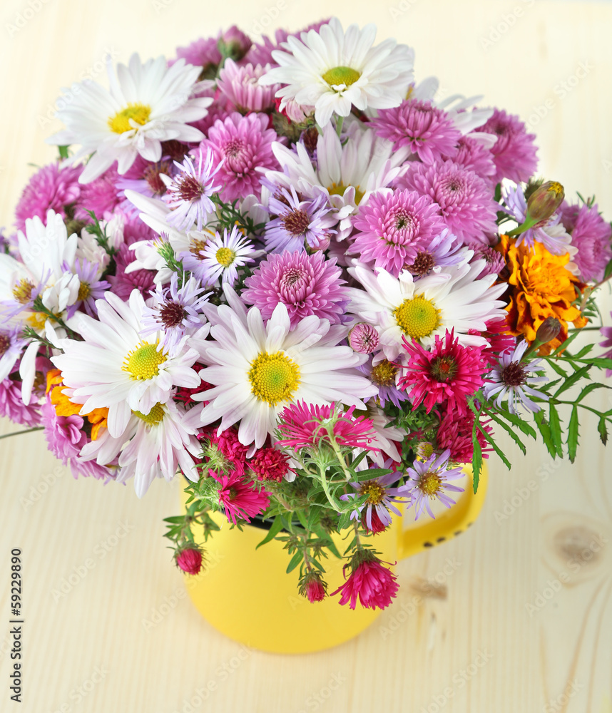 Wildflowers in mug on wooden table