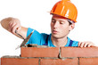 Construction mason installing red brick
