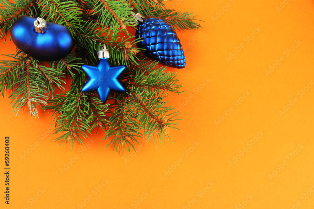 Beautiful Christmas decorations on fir tree on orange