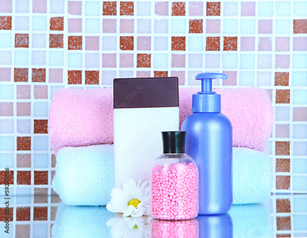 Cosmetics and bath accessories on mosaic tiles background