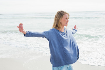 Woman standing with arms outstretched at beach