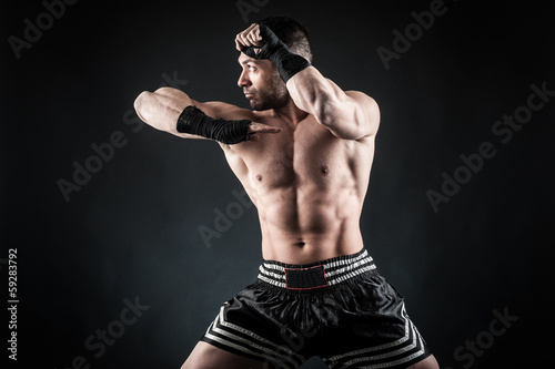 Board z aluminiowym obramowaniem Sportowiec kick boxer walczący z czarnym tłem.