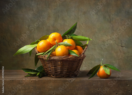 Tapeta ścienna na wymiar Still life with tangerines in a basket on the table