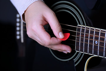 Acoustic guitar in female hands, close-up